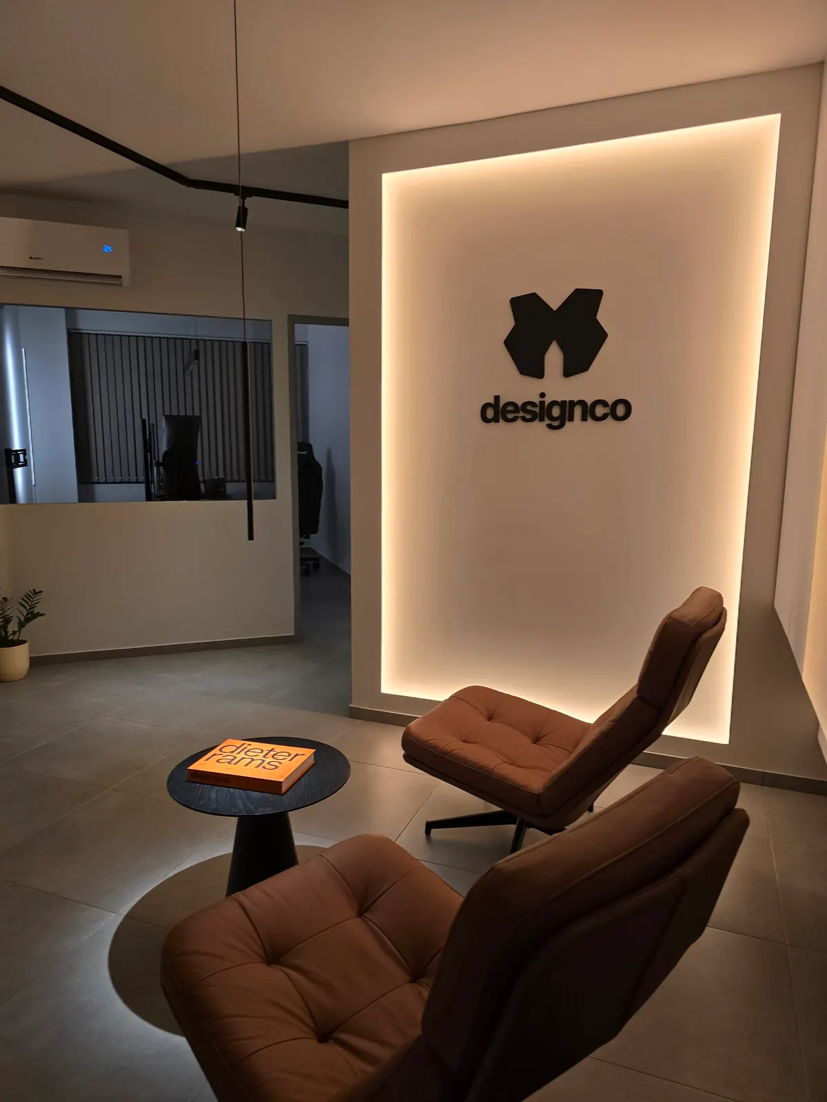 The lounge corner beneath the backlit Designco mark