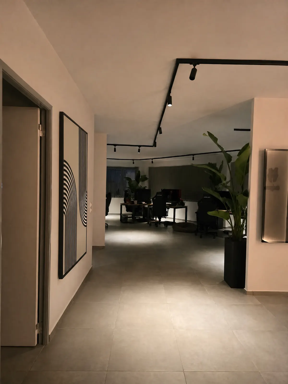 The passage into the open workspace, framed line art and evening light